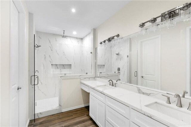 bathroom featuring a shower with door, vanity, and hardwood / wood-style flooring