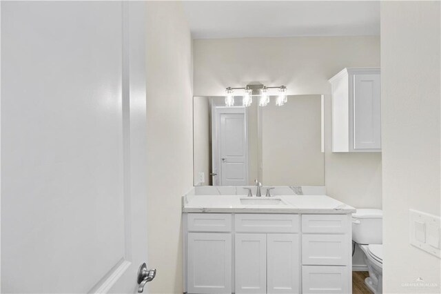 bathroom with hardwood / wood-style floors, vanity, and toilet