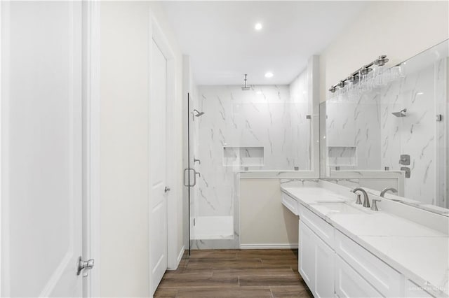 bathroom with wood-type flooring, vanity, and walk in shower