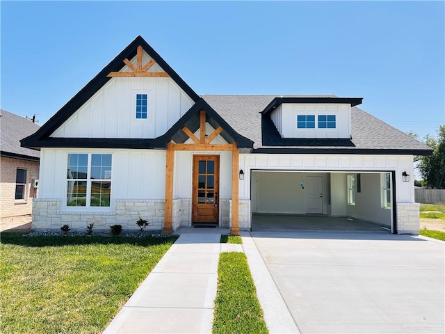 2201 Blue Sky Dr, Weslaco, TX 78599 - modern farmhouse with board and batten siding, stone siding, concrete driveway, a front yard, and a shingled roof