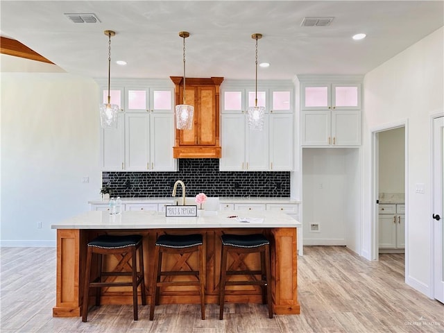 2201 Blue Sky Dr, Weslaco, TX 78599 - kitchen with a center island with sink, backsplash, light countertops, light wood finished floors, and recessed lighting