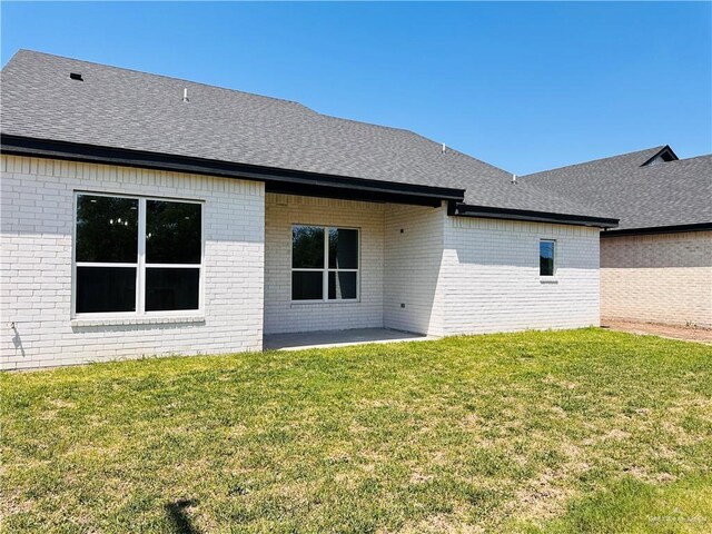 2201 Blue Sky Dr, Weslaco, TX 78599 - rear view of house featuring brick siding, a shingled roof, and a yard