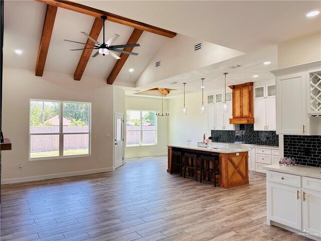 2201 Blue Sky Dr, Weslaco, TX 78599 - kitchen with open floor plan, a ceiling fan, light countertops, beam ceiling, and glass insert cabinets