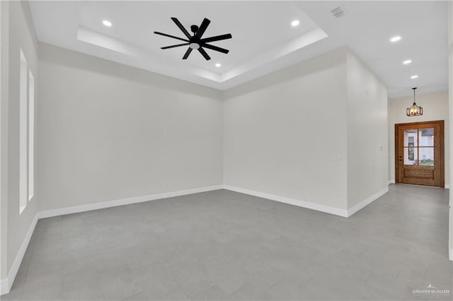 spare room with baseboards, visible vents, a tray ceiling, and recessed lighting