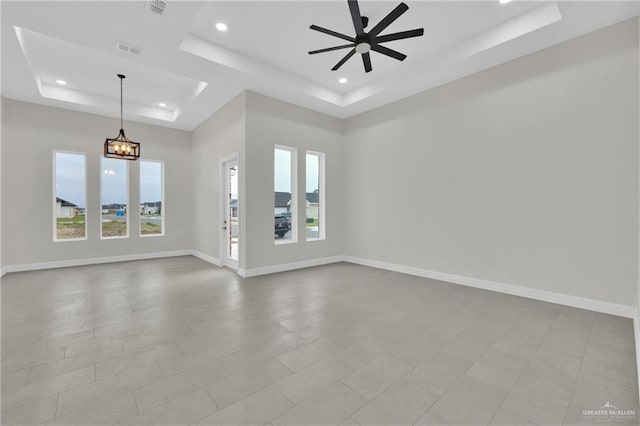 spare room featuring recessed lighting, a raised ceiling, visible vents, baseboards, and ceiling fan with notable chandelier