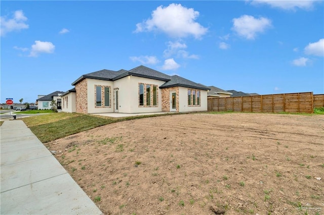 exterior space with fence private yard, a patio area, stucco siding, and a front yard