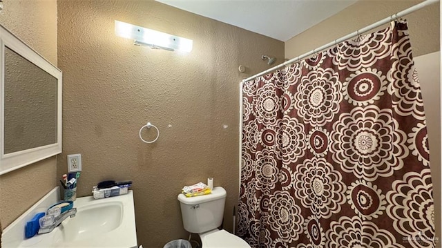 bathroom with sink, a shower with shower curtain, and toilet