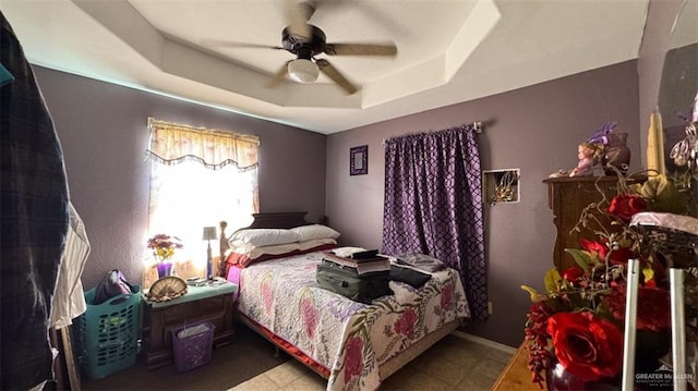 bedroom with a raised ceiling and ceiling fan