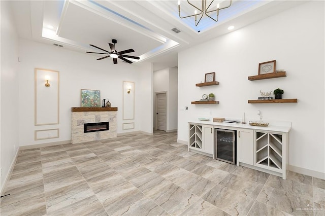 3721 Diamondhead Ave, Alton, TX 78573 - living room featuring wine cooler, a tray ceiling, a glass covered fireplace, a chandelier, and a ceiling fan