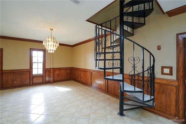 staircase featuring tile patterned floors, ornamental molding, and a notable chandelier