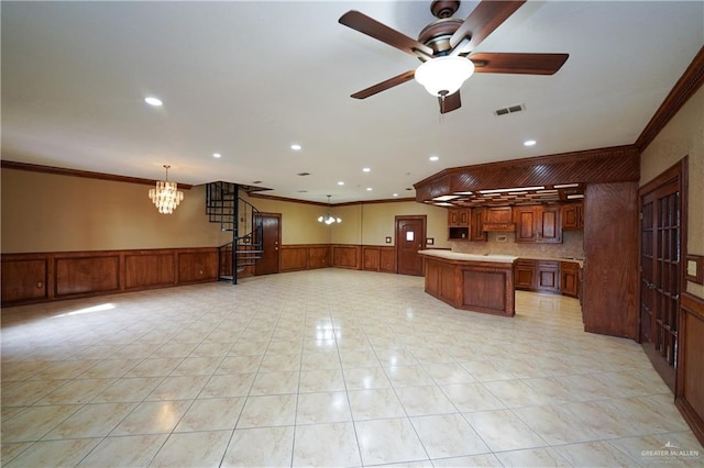 kitchen with pendant lighting, crown molding, a center island, and ceiling fan with notable chandelier