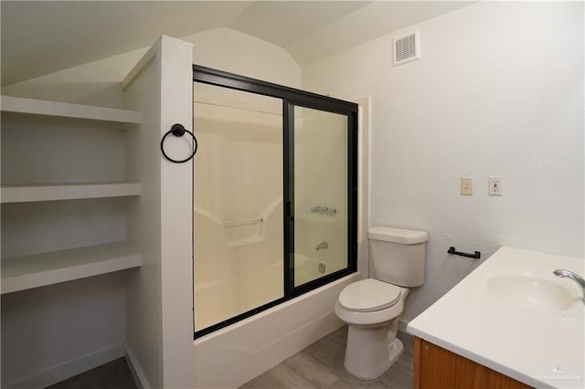 full bathroom with hardwood / wood-style flooring, enclosed tub / shower combo, vanity, vaulted ceiling, and toilet