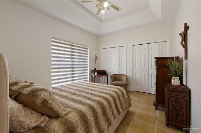 408 E Newport Ln, Mcallen, TX 78501 - bedroom featuring multiple closets, light tile patterned floors, a ceiling fan, and a tray ceiling