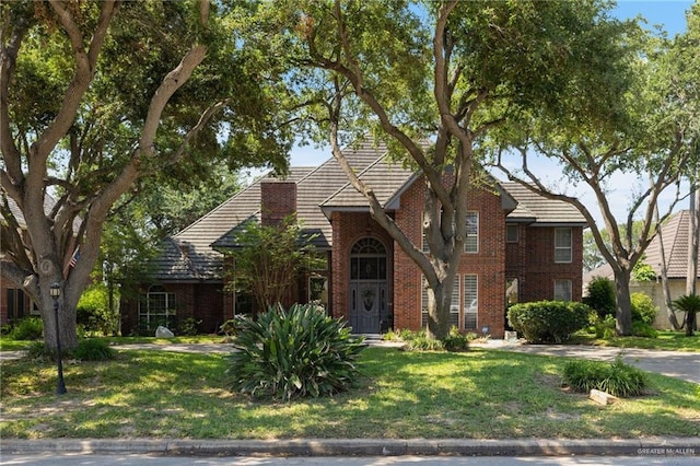 408 E Newport Ln, Mcallen, TX 78501 - traditional-style house with a front lawn and brick siding