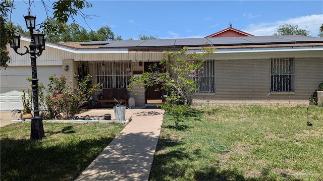2104 Harvey St, Mcallen, TX 78501 - single story home with brick siding, solar panels, a front lawn, and a garage