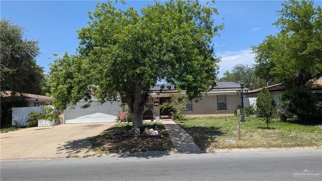 2104 Harvey St, Mcallen, TX 78501 - obstructed view of property with roof mounted solar panels, concrete driveway, and a front lawn