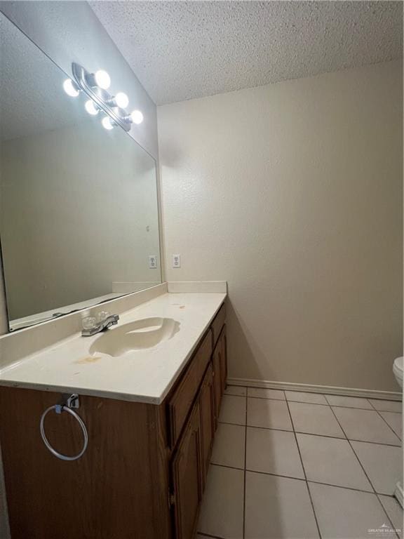 bathroom featuring tile patterned floors, vanity, a textured ceiling, and toilet