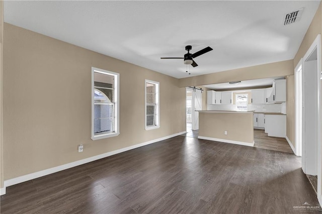 unfurnished living room featuring dark hardwood / wood-style flooring and ceiling fan