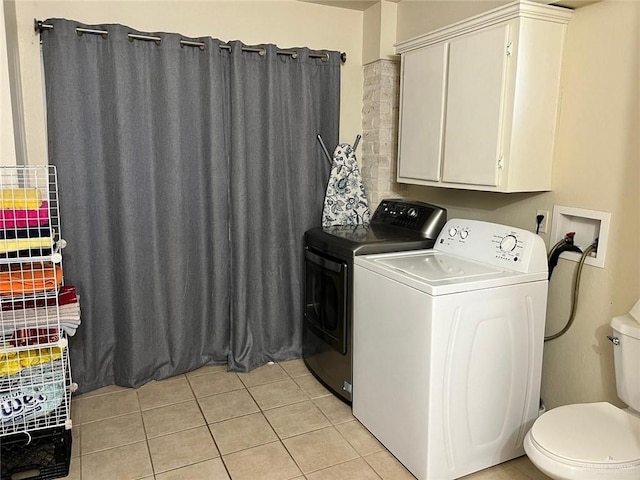 laundry area with separate washer and dryer and light tile patterned floors