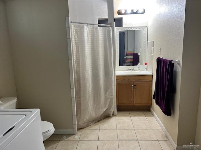 bathroom with tile patterned flooring, toilet, walk in shower, and washing machine and clothes dryer