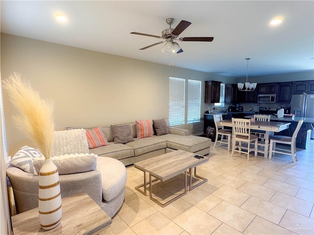 living room featuring ceiling fan with notable chandelier and light tile patterned flooring