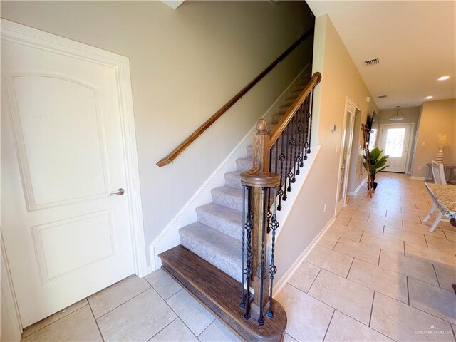 staircase featuring tile patterned flooring