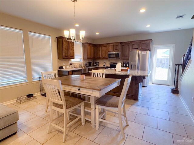 dining area with a notable chandelier and light tile patterned floors