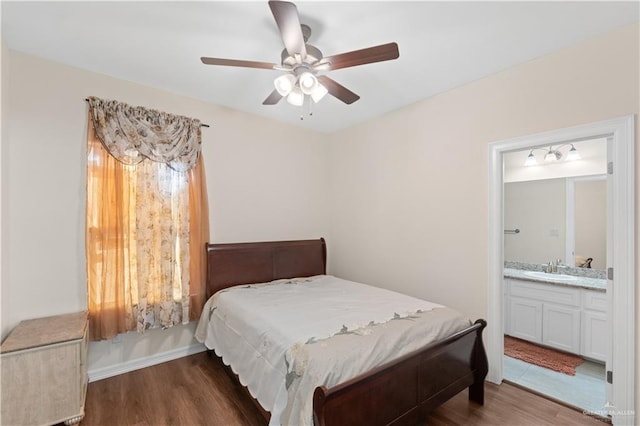 bedroom with ensuite bathroom, dark hardwood / wood-style floors, sink, and ceiling fan