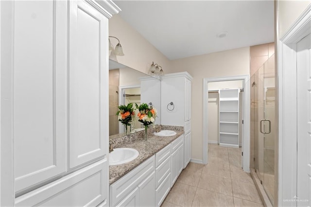 bathroom featuring vanity, a shower with shower door, and tile patterned floors