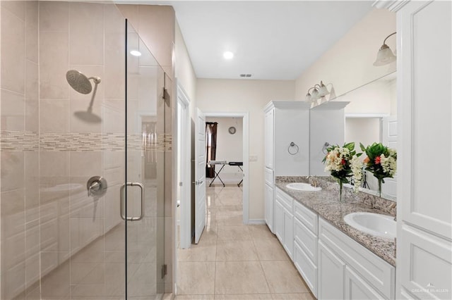 bathroom featuring vanity, a shower with shower door, and tile patterned floors