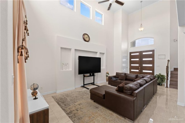 living room featuring ceiling fan and a high ceiling