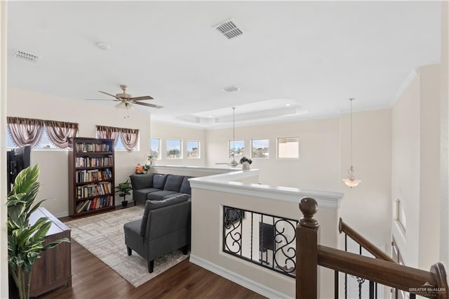 sitting room with a raised ceiling and dark hardwood / wood-style flooring