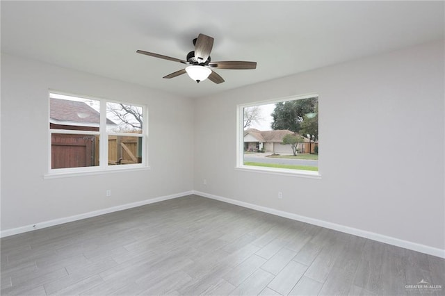 empty room featuring hardwood / wood-style floors, plenty of natural light, and ceiling fan