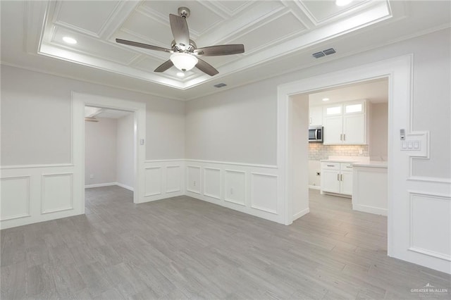 unfurnished room featuring coffered ceiling, crown molding, light hardwood / wood-style flooring, and ceiling fan