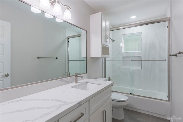 full bathroom featuring hardwood / wood-style flooring, enclosed tub / shower combo, vanity, and toilet