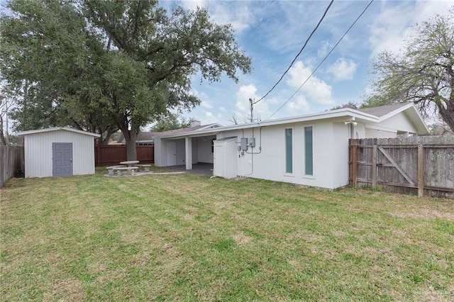 rear view of house with a yard and a storage unit