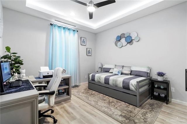 2215 Corales St, Mission, TX 78573 - bedroom featuring a raised ceiling, a desk, light wood-type flooring, and ceiling fan