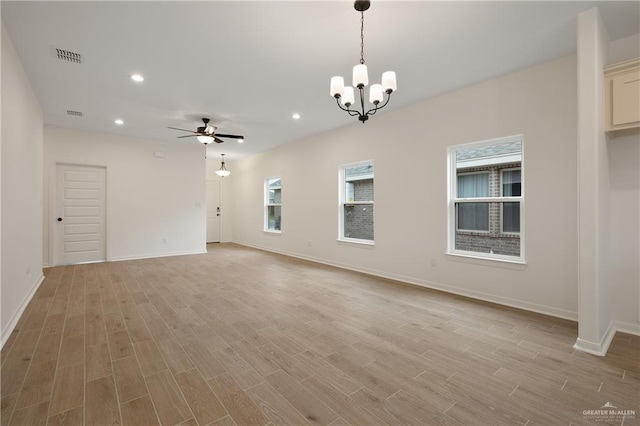 unfurnished room with light wood-style flooring, ceiling fan with notable chandelier, baseboards, and recessed lighting