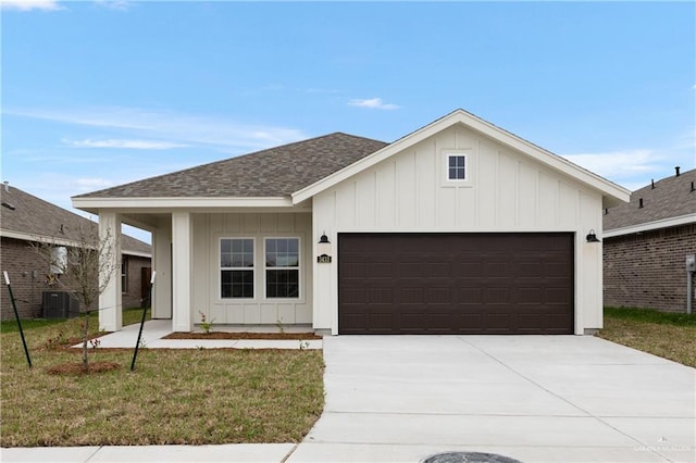 view of front of property with a garage, driveway, board and batten siding, and roof with shingles