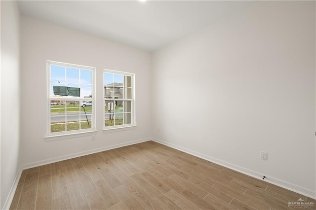 spare room featuring light wood-style flooring and baseboards