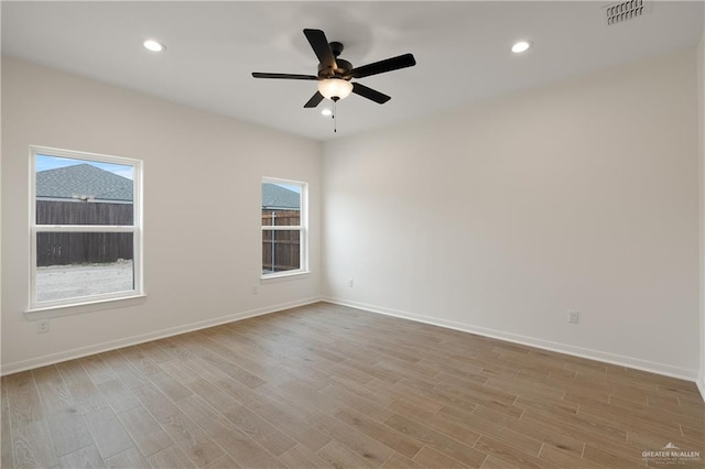 spare room with ceiling fan, light wood-style flooring, recessed lighting, visible vents, and baseboards