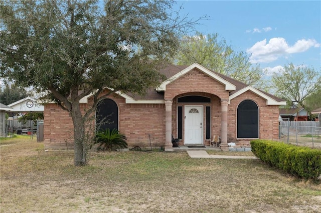 single story home with a front yard, brick siding, and fence