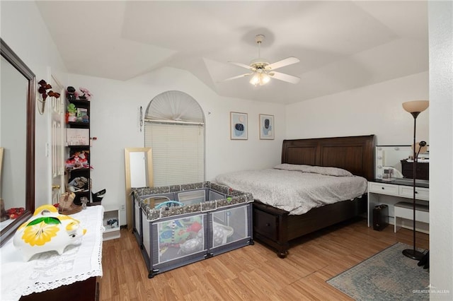 bedroom featuring vaulted ceiling, light wood-style flooring, and a ceiling fan