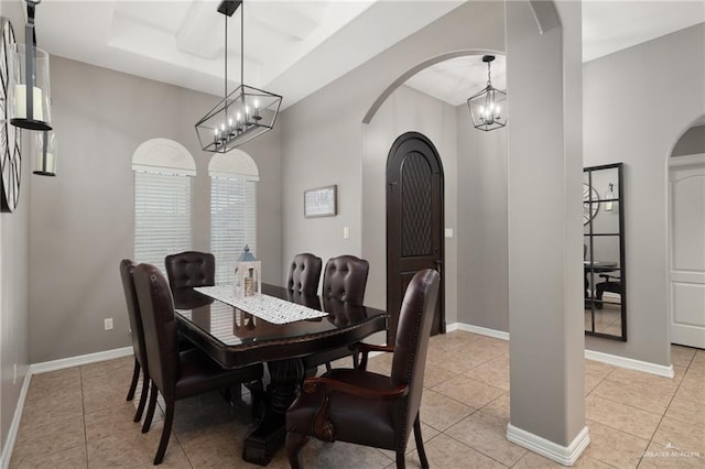 dining space with baseboards, arched walkways, and light tile patterned flooring