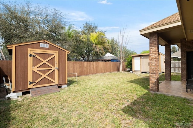 view of yard featuring an outbuilding, a patio, a storage shed, and a fenced backyard