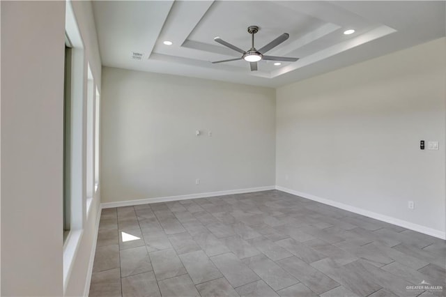 spare room with a raised ceiling and ceiling fan