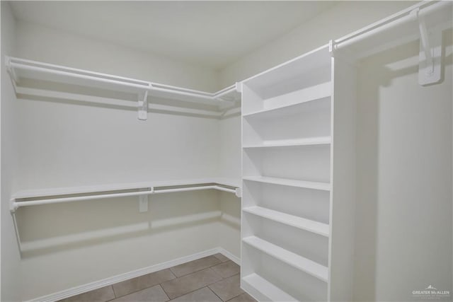 walk in closet with light tile patterned floors