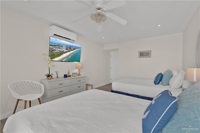 bedroom with wood finished floors, an AC wall unit, baseboards, and ceiling fan