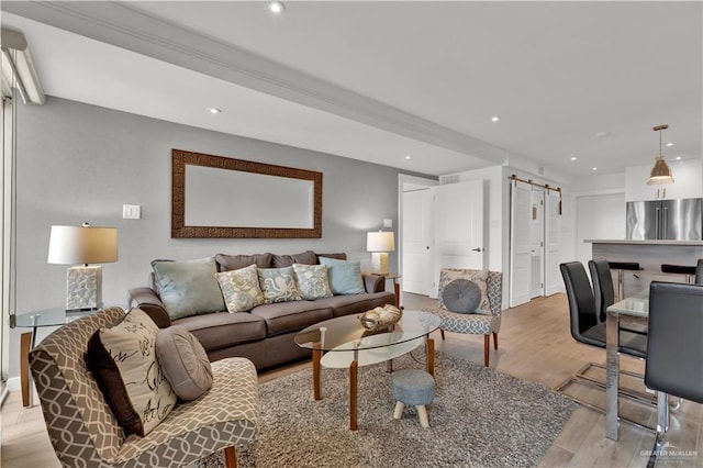 living area with visible vents, recessed lighting, light wood-style floors, and a barn door