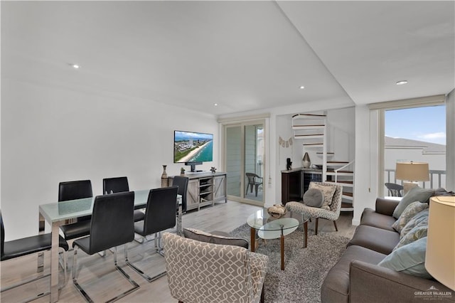 living area with recessed lighting, stairs, and light wood-style floors